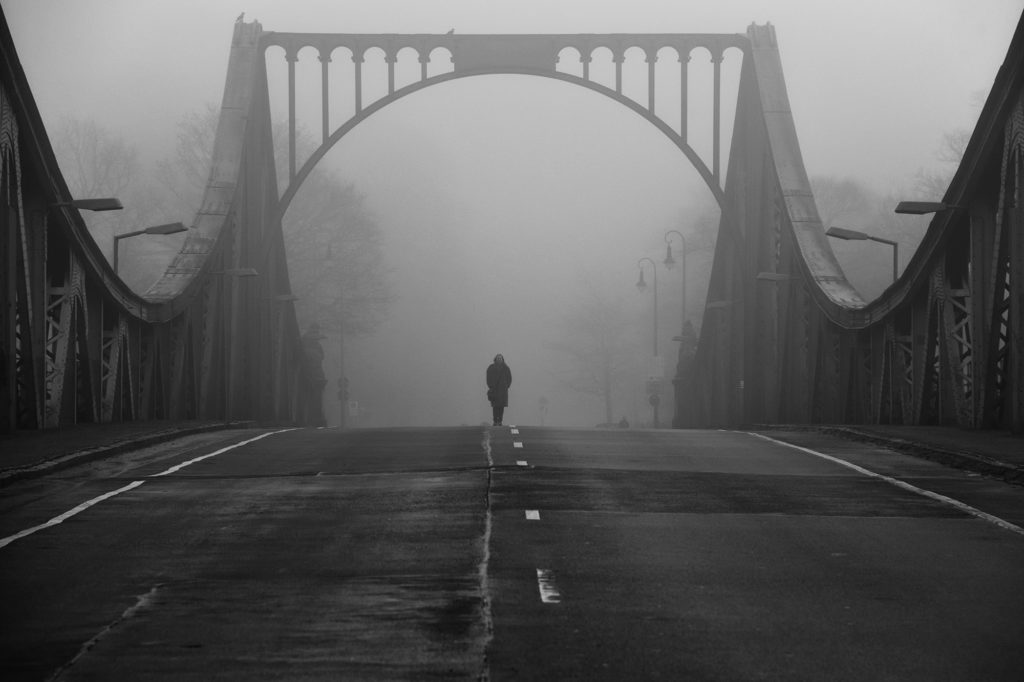 Auf der Glienicker Brücke am 11. Januar 2016. Es ist neblig und steht mit der in der Mitte der Brücke platzierten Person für den Agentenaustausch während des kalten Krieges zwischen Ost und West