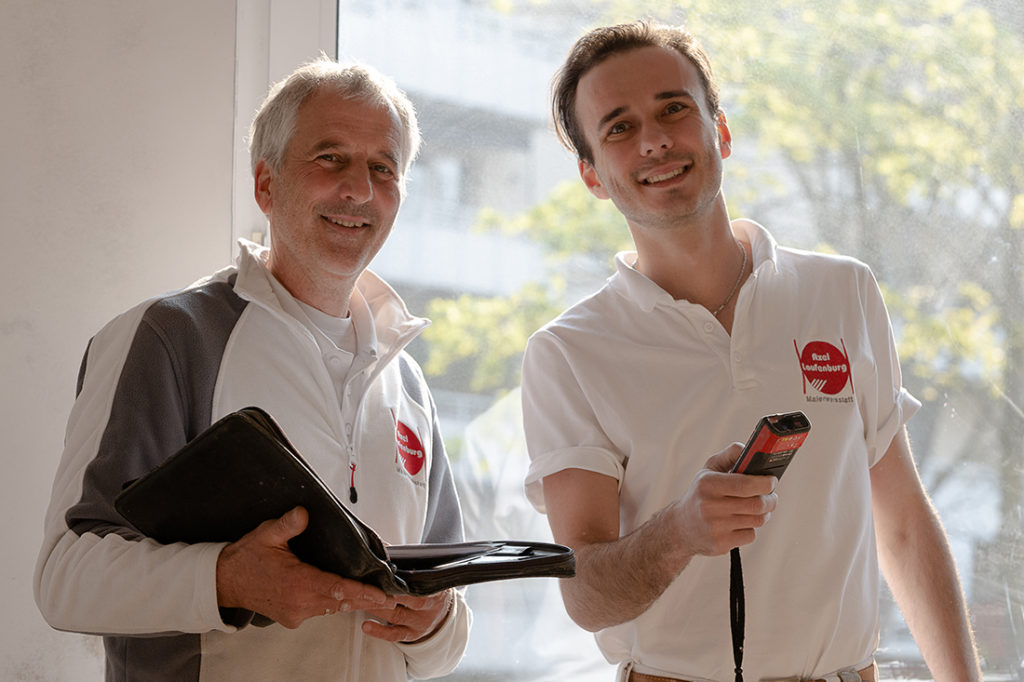 Malermeister und Sohn strahlen in die Kamera, Businessbild